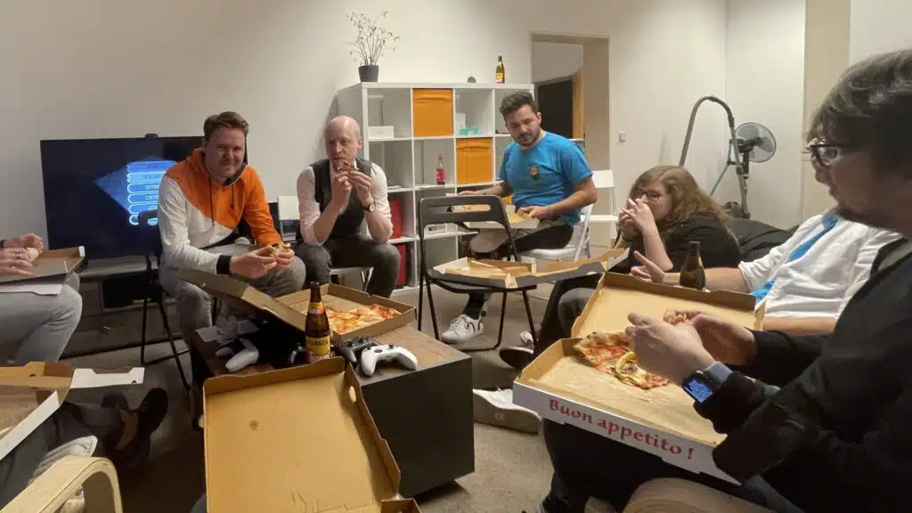 Menschen essen Pizza und sprechen über Spiele